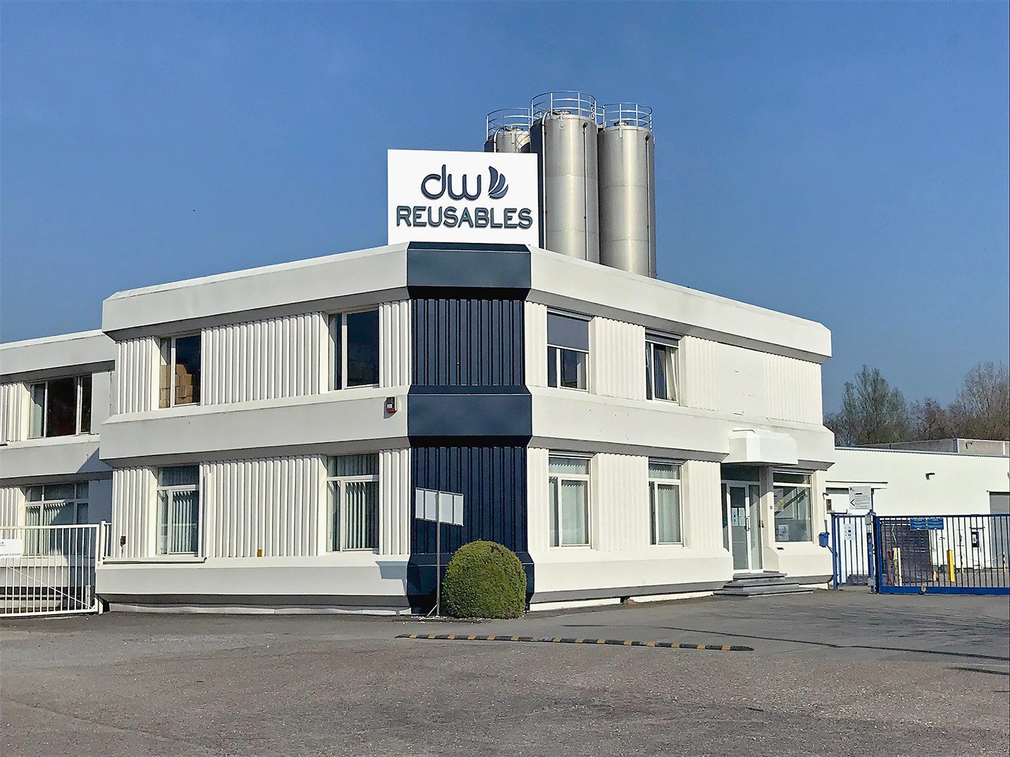 Außenansicht des Hauptsitzes und der Produktionsstätte von DW Reusables in Bilzen, Belgien, wo wiederverwendbare Verpackungslösungen entworfen, entwickelt und hergestellt werden.