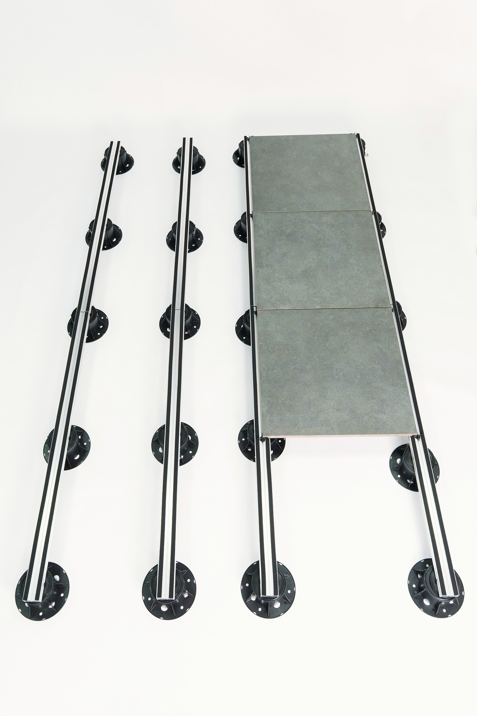 Un sistema modular de pedestales con perfiles de aluminio ofrece una base estable y regulable para una instalación precisa de pavimentos exteriores.